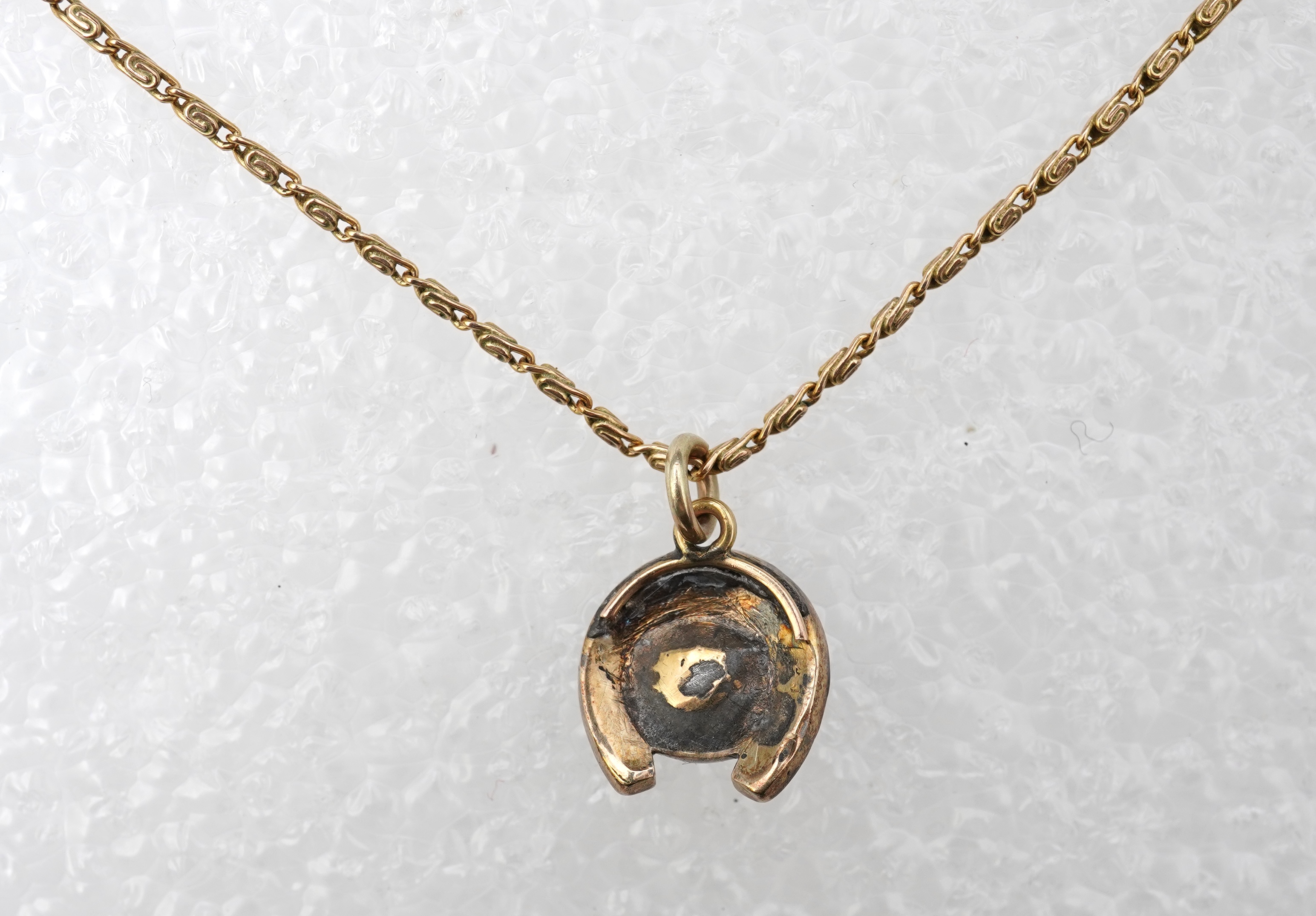 A yellow metal, cat's eye quartz and rose cut diamond cluster set horseshoe pendent, 11mm, together with a 9ct gold chain, 41cm, gross weight 5 grams.